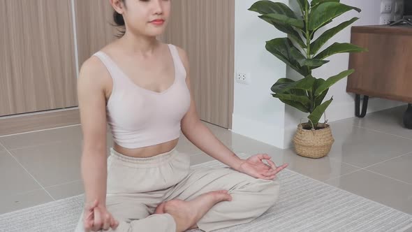 A mixed-race Chinese woman sits on the floor in the living room alt