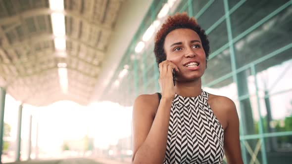 Young Beautiful African Businesswoman Speaking on Phone Smiling Business Centre Background alt
