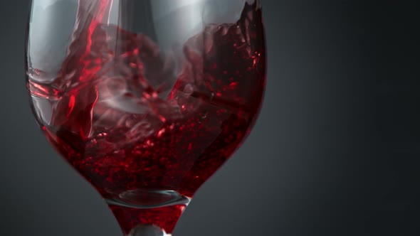 Pouring Red Wine in Super Slow Motion on Grey Background alt