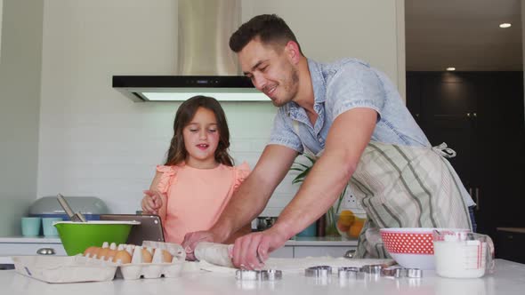 Happy caucasian father and daughter baking together in kitchen alt