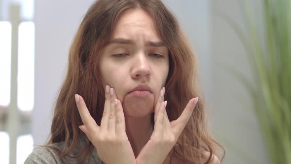 Upset Teenager Girl Looking Problem Skin and Touching Face Front Bathroom Mirror alt