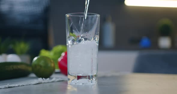 Transparent Glass that is Filled with Fresh Water on the Kitchen Background alt