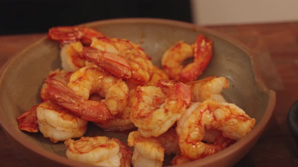 Cinematic slow motion arc shot of a bowl of perfectly cooked juicy and al dente peeled shrimps, prep alt