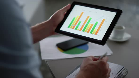 Business Man Researching Charts Graph Using Tablet Computer Pad in Remote Office alt