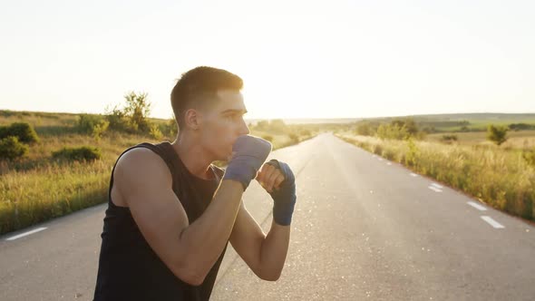 Profile of Kickboxer in Sportswear with Wrapped Hands in Tapes Trains Kicks alt