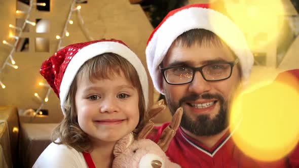 Father with Girl Look at Camera Smile and Laugh on Background of Christmas Decorations