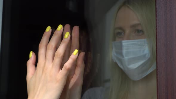 Two girls, sisters touch their hands with their palms through a glass window, alt