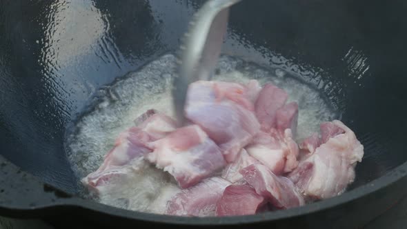 Cooking Process, Frying Pork Meat In Large Cauldron On Open Fire