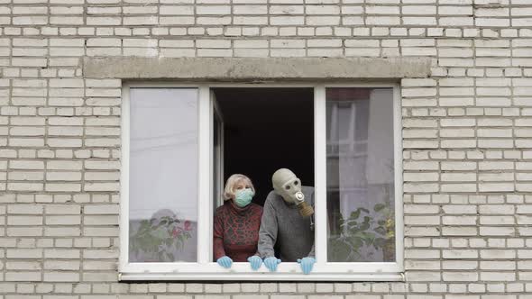 Old Grandparents Stay at Window Isolated at Home on Quarantine. Coronavirus alt