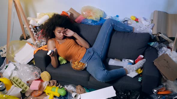 Woman lying on the couch and watching TV. 