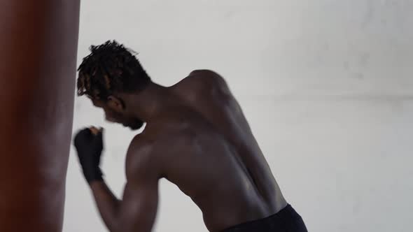 Shirtless African American Male Boxer Enjoying Training at Boxing Studio with Wrapped Hands alt