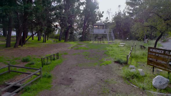 A drone push in of a ranger tower at the top of a mountain. Cinematic, golden hour. alt