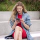 Young Woman with Smartphone Sitting on Street - VideoHive Item for Sale