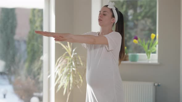 Live Camera Follows Young Pregnant Woman Squatting at Home in the Morning alt