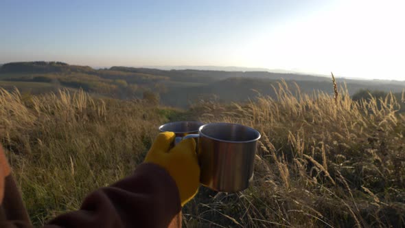 woman hold mugs of tea in mountains Sudetes in November in sunset