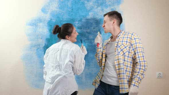 Joyful Guy and Lady Pretend to Sing Into Paintbrushes As Mic alt