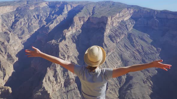 Young Foreign Female Tourist Enjoying the View of Wadi Ghul Aka Grand Canyon of Oman in Jebel Shams alt