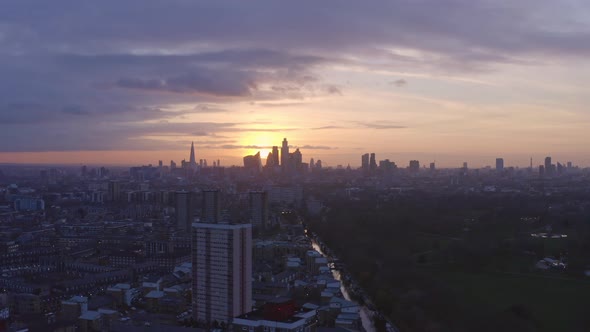 circling Aerial drone shot of London Canal towards city skyline at sunset alt