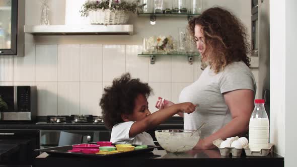 Black Little Girl Licks Raw Liquid Dough From Spoon alt