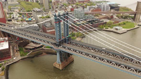 An aerial view over the East River on a cloudy day. The drone camera elevates and pan right along th alt