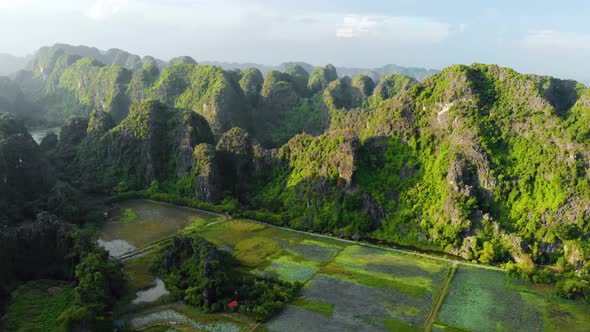 Aerial: North Vietnam karst landscape at sunset, drone view of Ninh Binh region, tourist destination alt