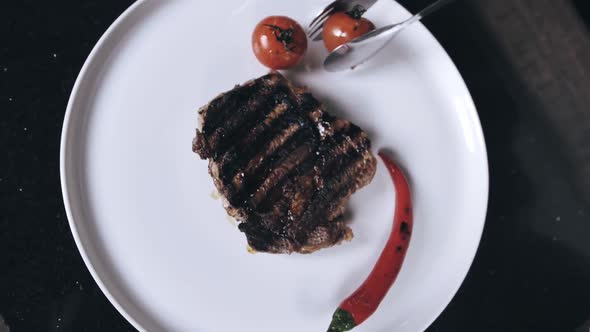 Chef is Putting Grilled Veggies on the Plate with a Steak on It Restaurant Meal alt