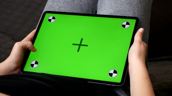 Chroma key tablet screen with tracking markers in the lap 4K footage