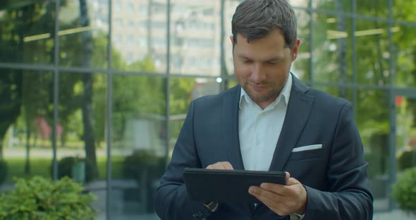 Man Holding Modern Digital Tablet. Businessman Typing on His Digital Tablet. Businessman Read News alt