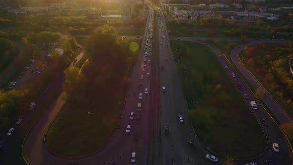 Aerial view of city traffic during rush hour at sunset alt