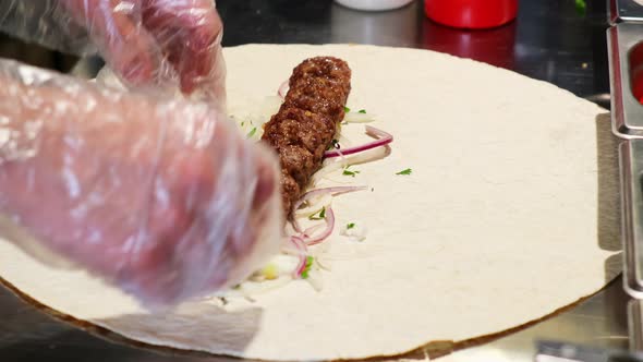Chef cooking lula kebab. Cook rolling kebab