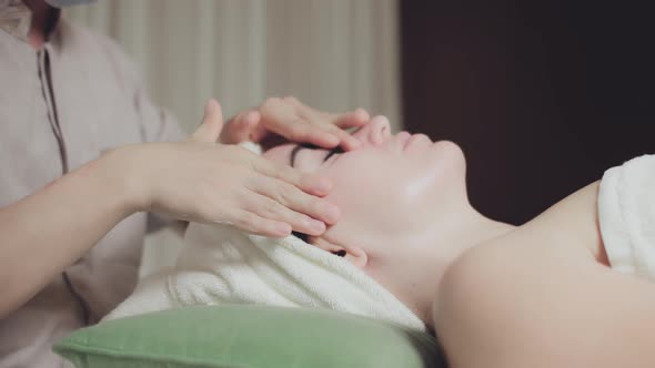 Young Beautiful Caucasian Woman Lying on a Spa Bed Receiving a Lip Massage with Skin Care with alt