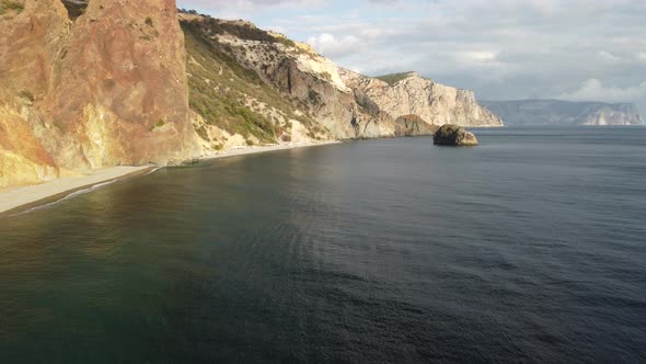Aerial View From Above on Calm Azure Sea and Volcanic Rocky Shores alt