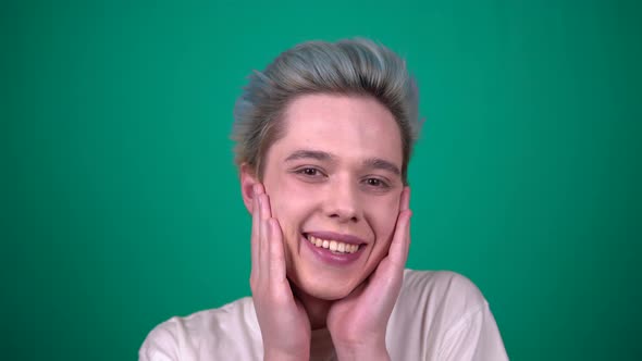 Cute Young Man with Color Hair Touches Melt Smiling on Blue Background