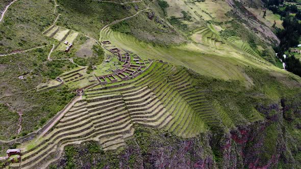 Inca Ruins In Hillside Curved Terraces Overlooking Pisac Old Town In Cusco, Peru. Aerial Pan Right alt