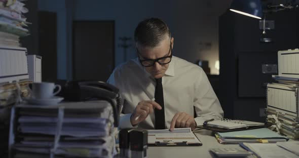 Corporate businessman sitting at desk and checking the calendar