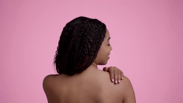 Back View Shot of Young Pretty Unrecognizable African American Lady Applying Pampering Cream on Her alt