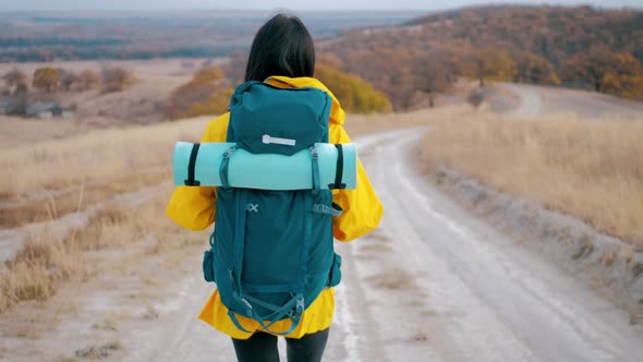 Woman Traveler with Backpack Exploring on Top of Mountains alt
