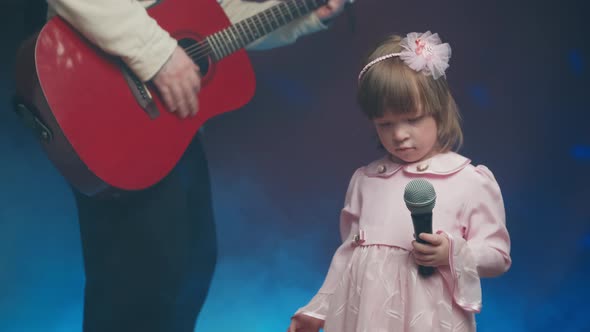 Llittle Girl in Vintage Dress Sings on Stage Her Father Plays Acoustic Guitar