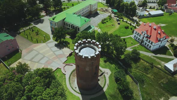 Flight Over A Provincial Town. An Ancient Tower Among The Multi Colored Roofs Of Houses alt
