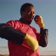 African-American man boxer in sportswear warms up and stretches muscles before training outdoor, fro - VideoHive Item for Sale