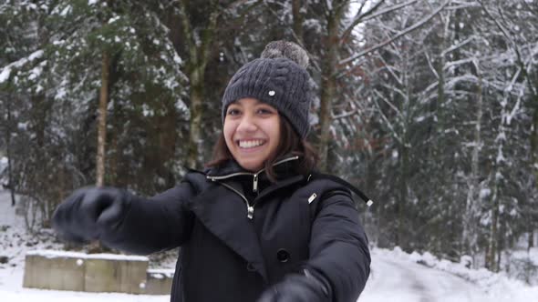 Young asian woman having fun in the snow jumping and warming up in slow motion. alt