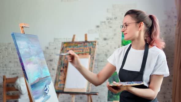 Happy Talented Young Woman Painter Enjoying Drawing Picture at Art Studio Medium Shot alt