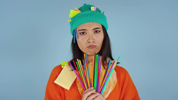 Asian woman holding plastic straws.