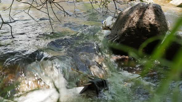 a Mountain River with a Fast Flow of Water is Polluted with Debris From Plastic Polyethylene and