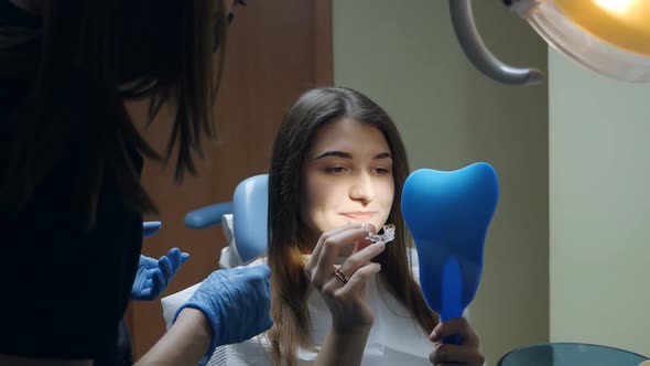 Young Woman Putting on Transparent Plastic Retainers in the Dental Office