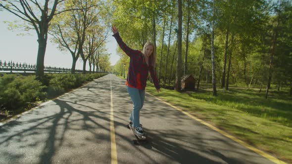 Pretty Female Skateboarder Enjoying Freedom and Leisure During Skateboarding alt