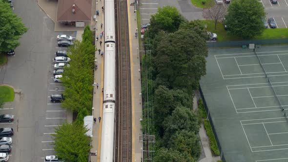 Aerial View of MTA Train Stopped at Station Near Tennis Courts in Long Island alt