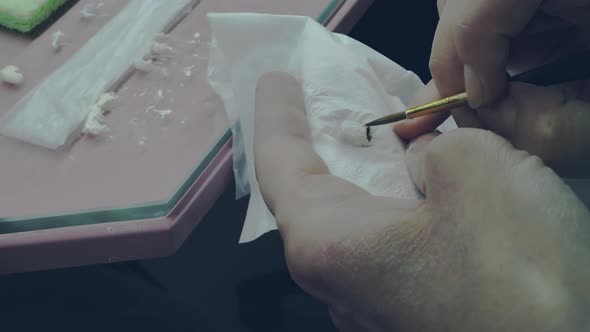 The Hands of the Sculptor of the Prosthetic Office Apply Enamel to the Dental Implant alt