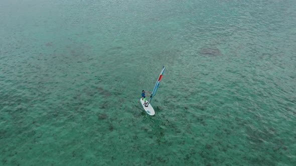 Aerial View of Windsurfer Surfing in in Calm Deep Blue of Sea Extreme Summer Sport Activity alt