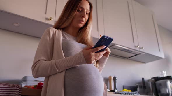 Pregnant woman eating healthy food and using mobile phone. Shot with RED helium camera in 8K alt